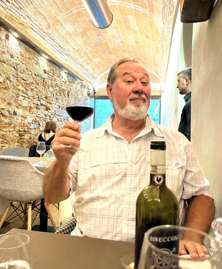 V. Les Rogers tasting wine at Florence restaurant