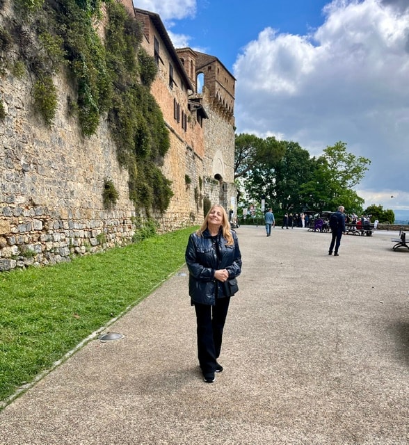 Woman walking historic castle grounds San Gimignano